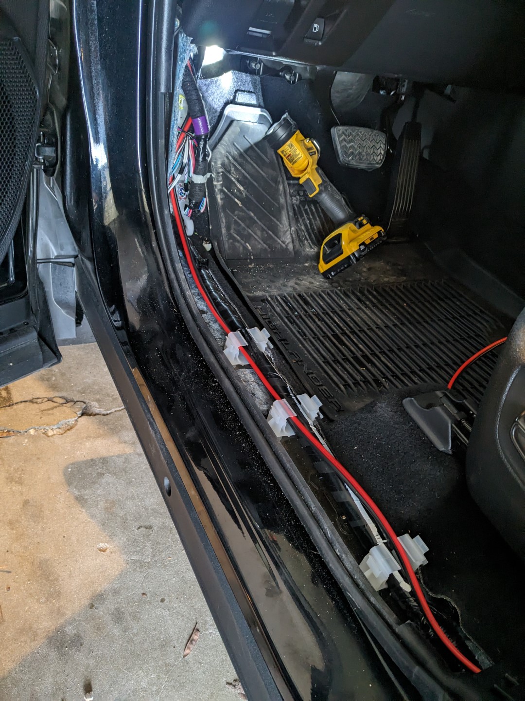 The power cable coming into the passenger compartment, and feeding rear to the under side of the drivers seat.