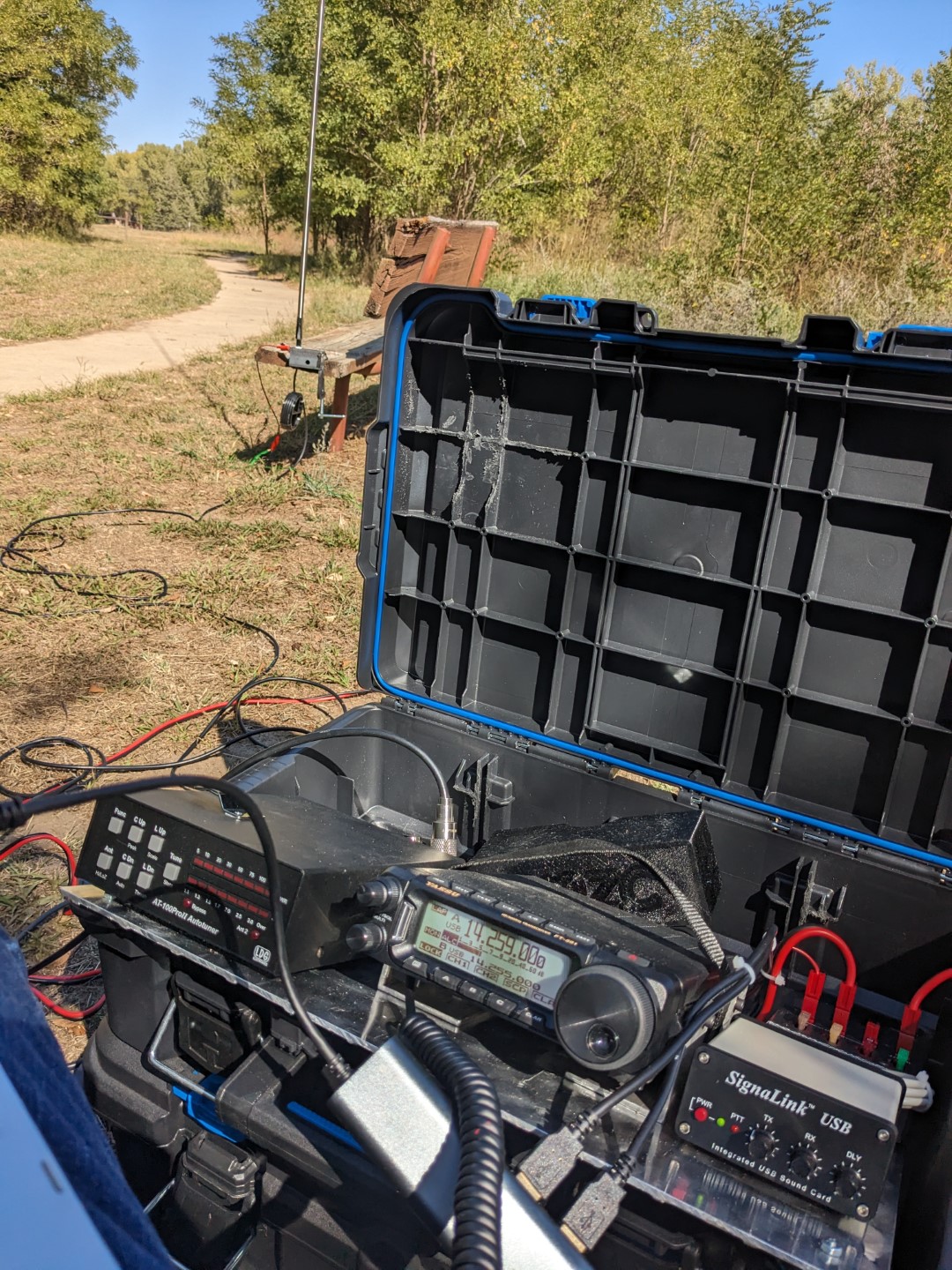 The radio kit in the field, connected to a vertical antenna.