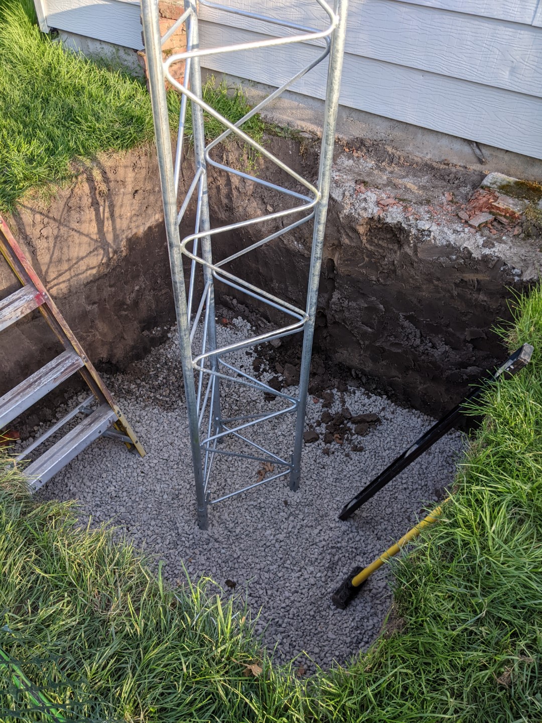 The tower base sitting in the hole, waiting for rebar and concrete.