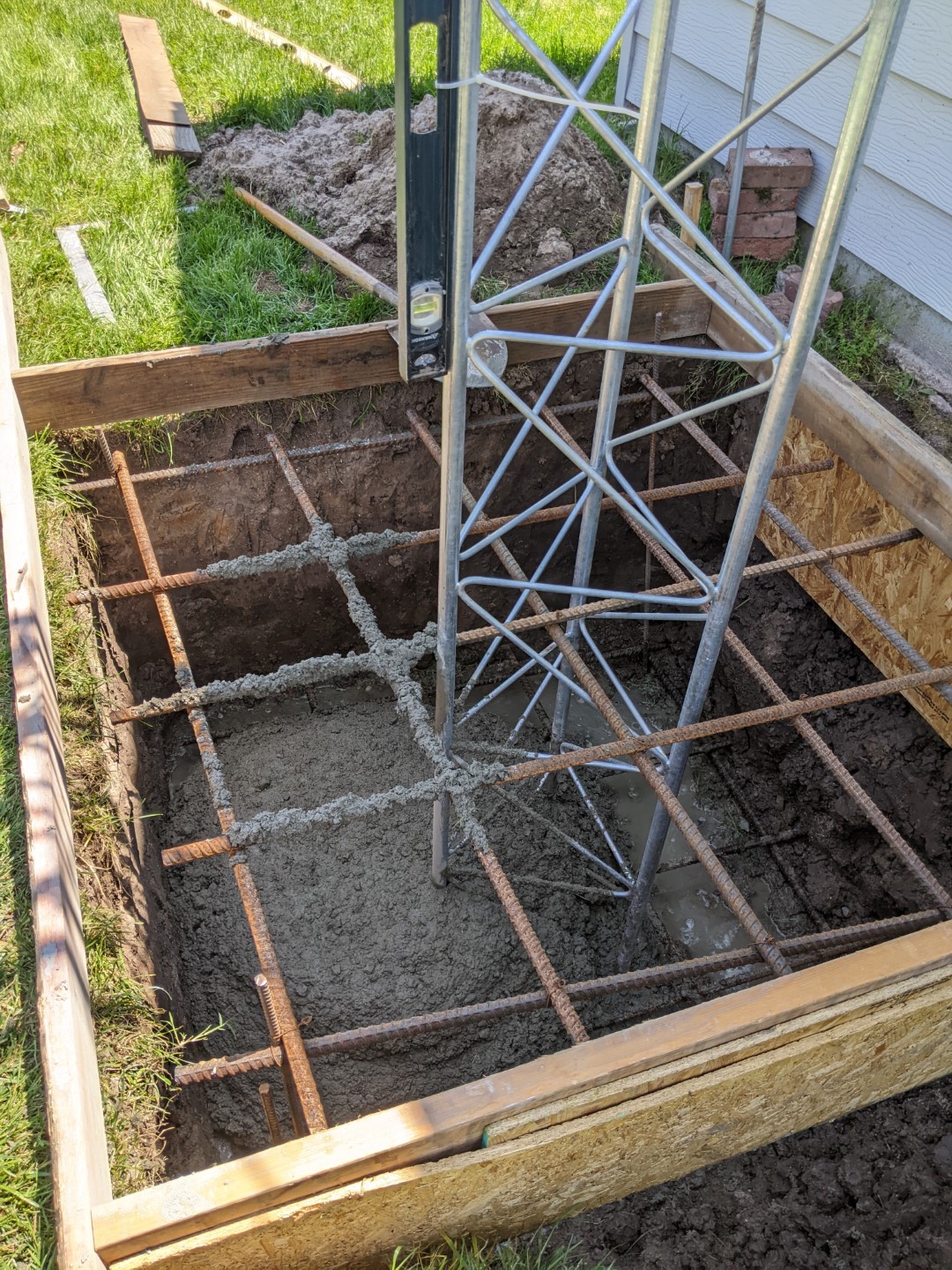 The tower base being set into concrete with the rebar cage around it.